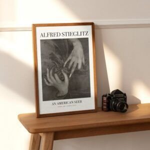 Framed photo beside camera on wooden table.