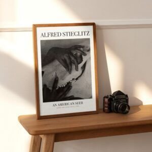 Framed Alfred Stieglitz photo beside vintage camera.