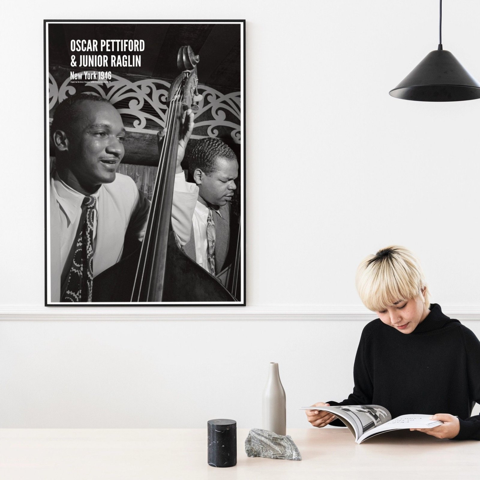 Person reading by a Jazz musicians' photo.