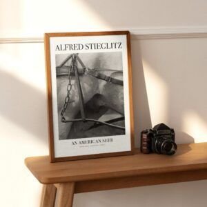 Framed Alfred Stieglitz photo on wooden shelf.
