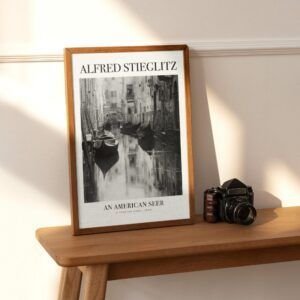 Framed artwork beside vintage camera on wooden table.
