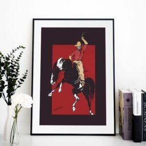 Cowboy artwork in black frame on white shelf.