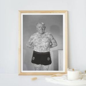 Tattooed man framed photo on display table.