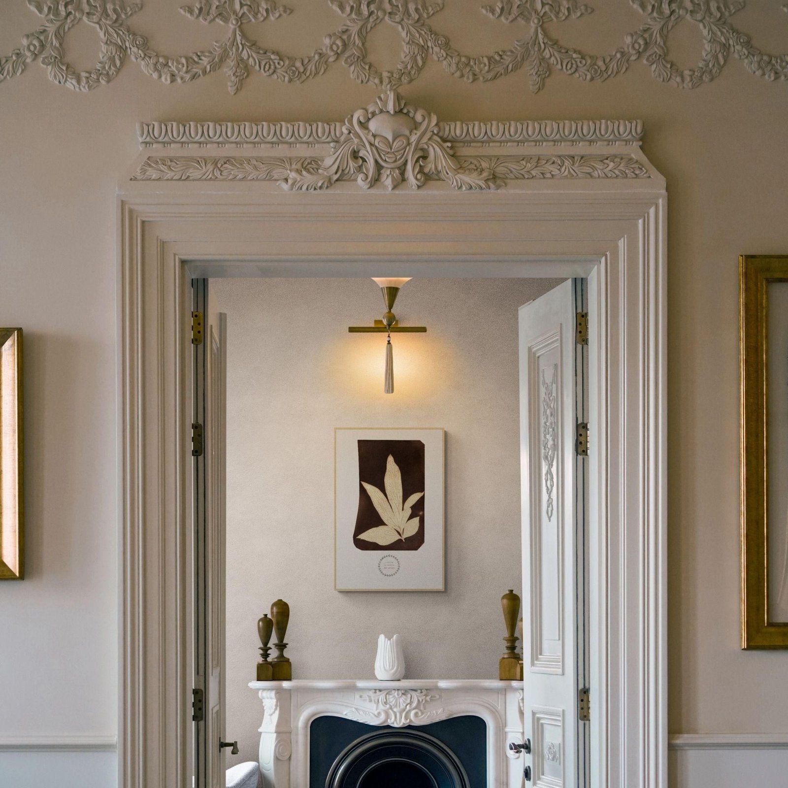 Elegant room with ornate fireplace and artwork.
