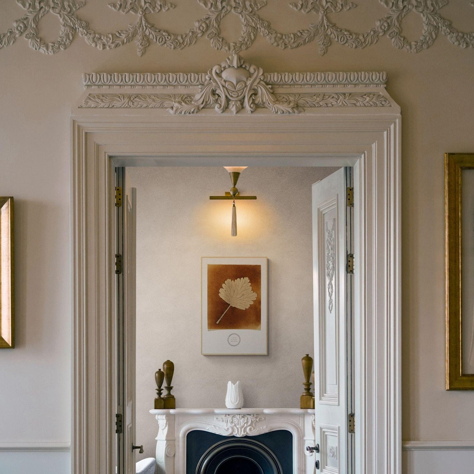 Elegant room with intricate molding and framed artwork.