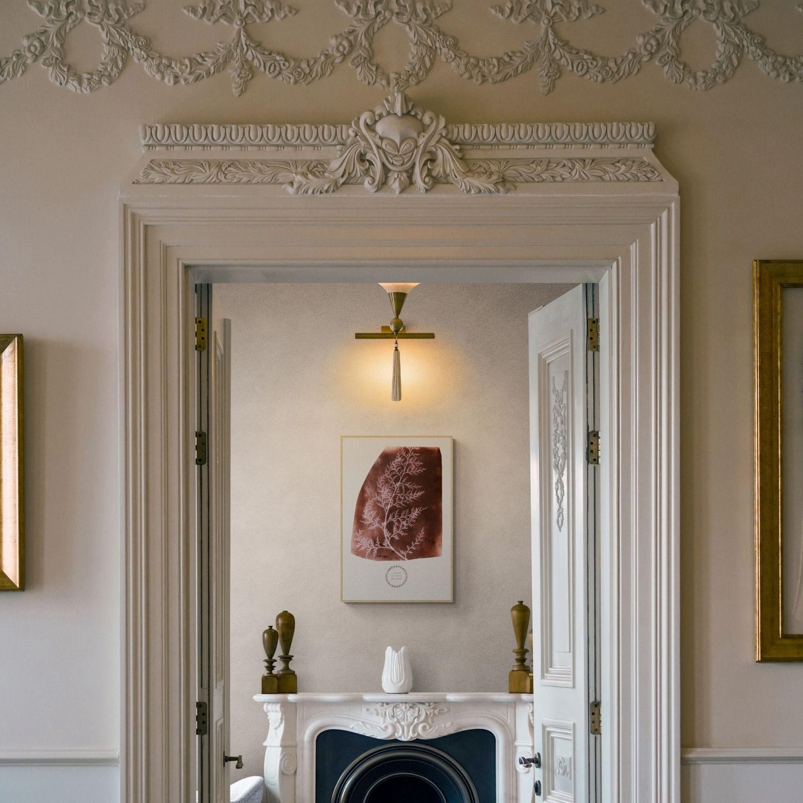 Elegant interior with ornate fireplace and framed artwork.