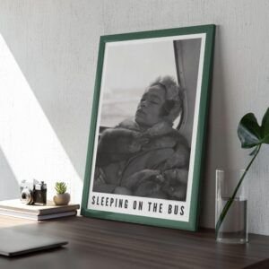 Framed photo titled 'Sleeping on the Bus' on table.