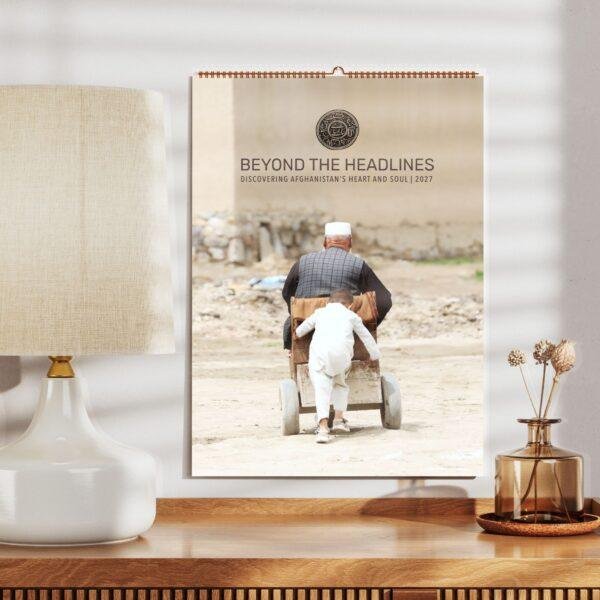 2027 Afghanistan wall calendar displayed on wooden shelf