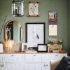 Stylish green-walled room with gallery art and white dresser
