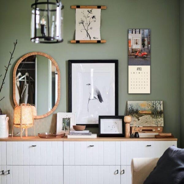 Stylish green-walled room with gallery art and white dresser