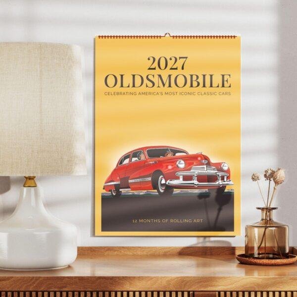 2027 Oldsmobile classic car wall calendar on wooden shelf