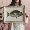 Woman holding framed vintage parrotfish botanical illustration