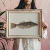 Woman holding framed vintage fish illustration art print