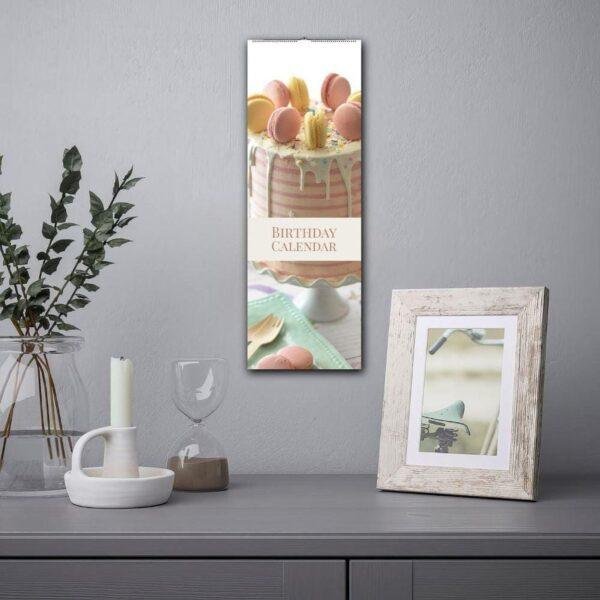 Birthday calendar with cake design hanging on gray wall