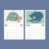 2027 wall calendar showing July turtle and August cat illustrations