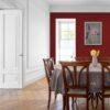 Elegant dining room with bold red accent wall and wooden furniture