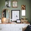 Stylish green-walled room with gallery wall and white sideboard