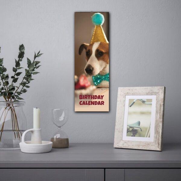 Dog birthday calendar hanging on wall above styled shelf