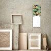 April 2027 floral wall calendar hung above eclectic frames