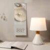 2027 minimalist wall calendar beside a glowing table lamp