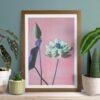 Framed lotus flower art print surrounded by houseplants