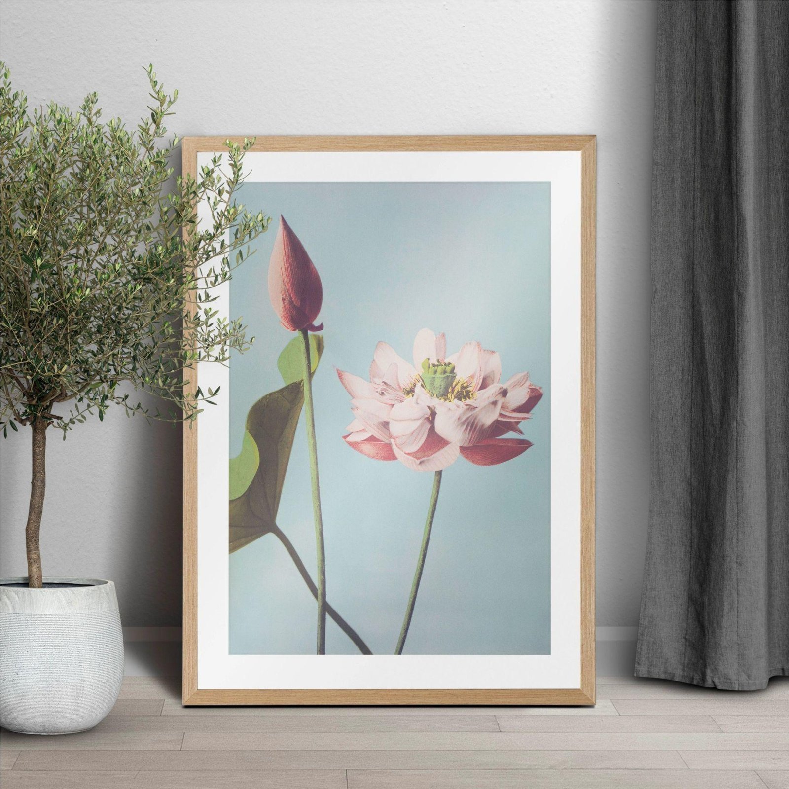 Framed lotus flower print leaning against white wall