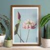 Framed lotus flower print surrounded by houseplants