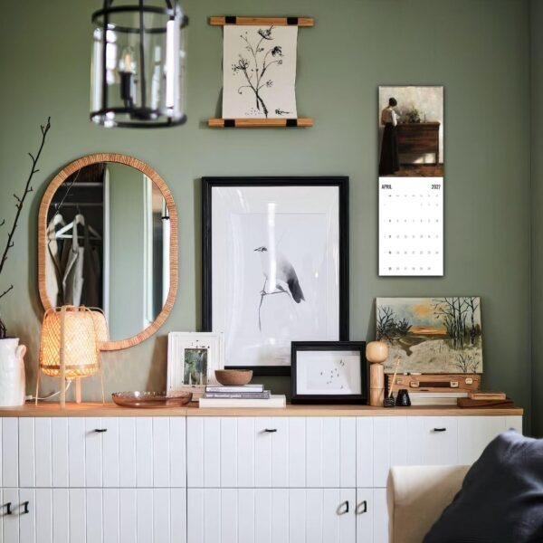 Stylish green bedroom dresser with gallery wall and mirror