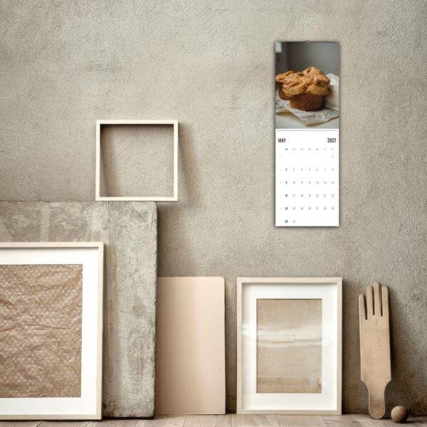 May 2027 bakery calendar hanging on rustic wall