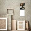 April 2027 wall calendar hanging above artistic frames