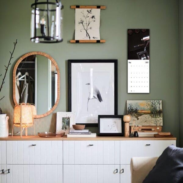 Stylish green living room with gallery wall and white sideboard