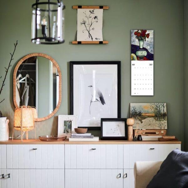 Stylish green living room with gallery wall and white sideboard