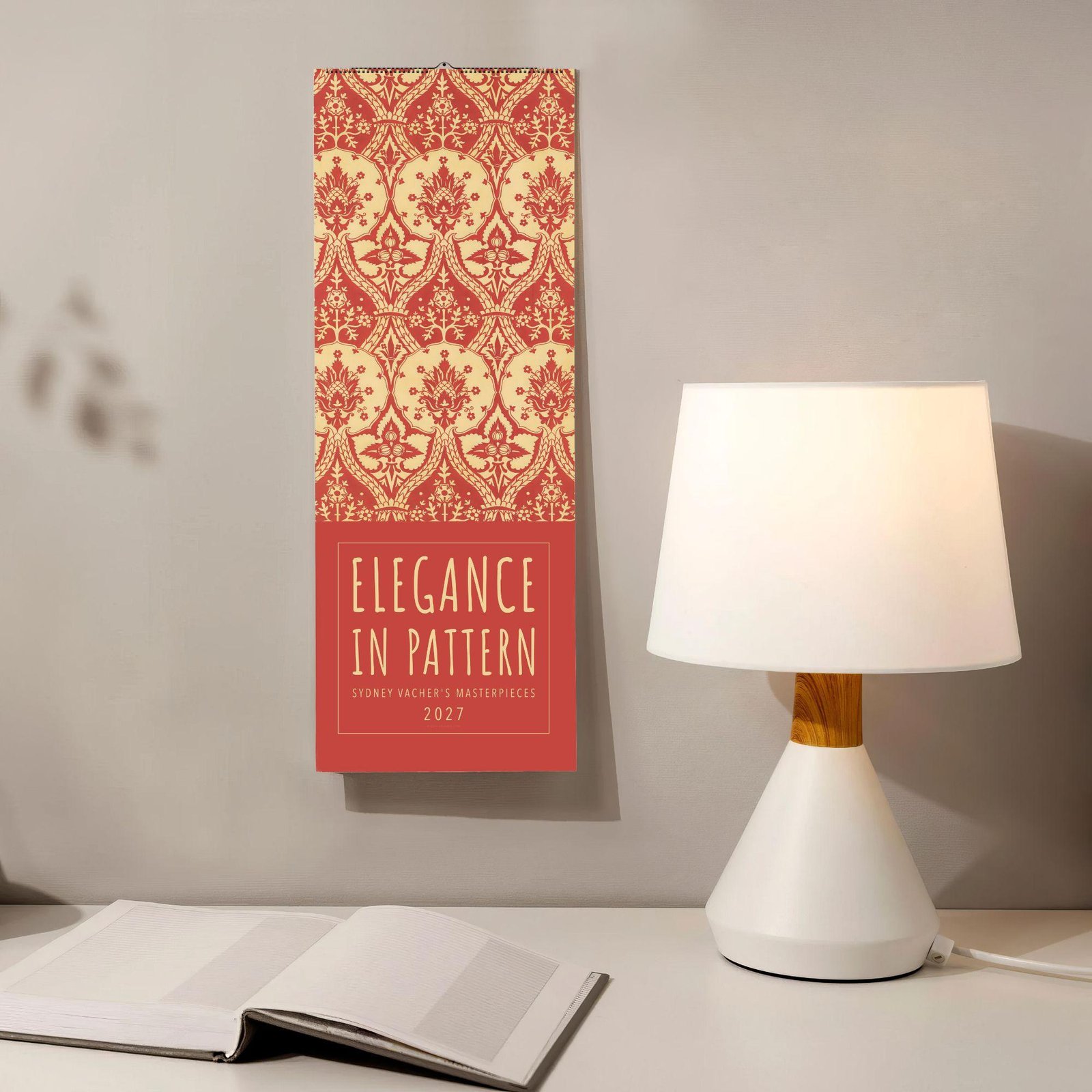 Elegant red floral pattern 2027 wall calendar beside desk lamp