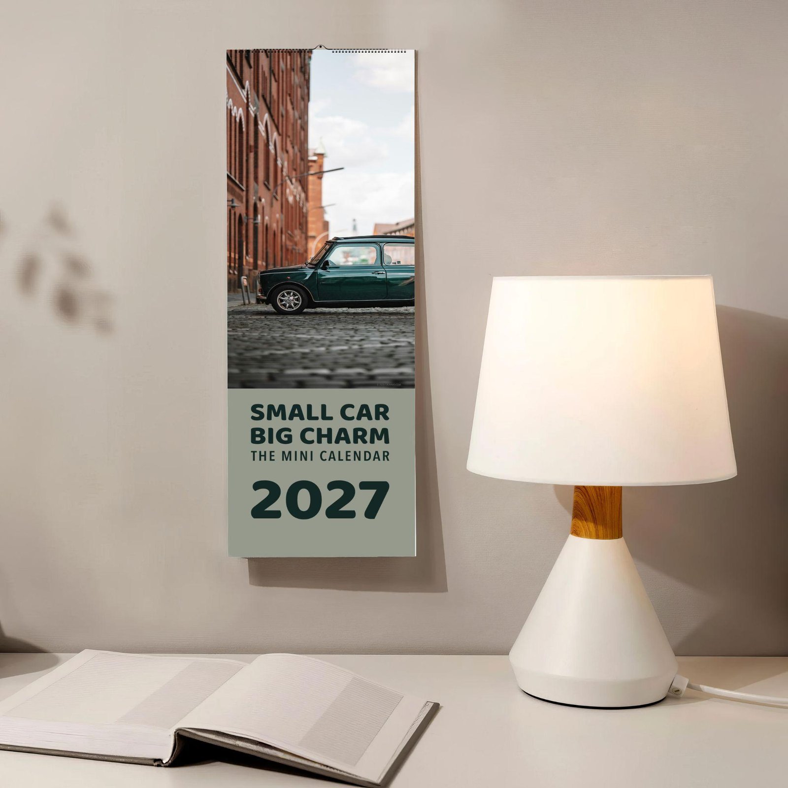 2027 Mini Car wall calendar hanging beside a desk lamp