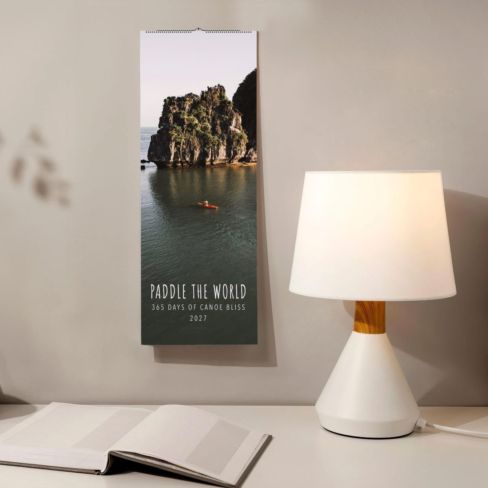 2027 Paddle the World canoe wall calendar on desk