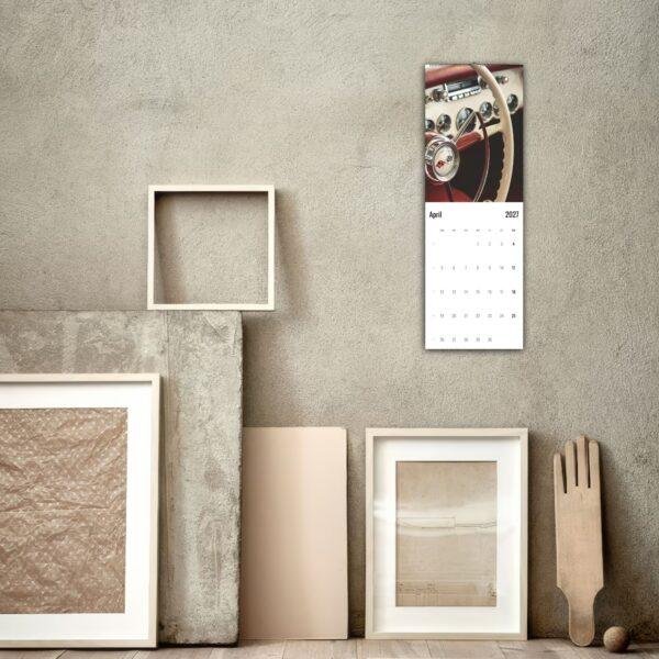April 2027 classic car wall calendar hung on concrete wall