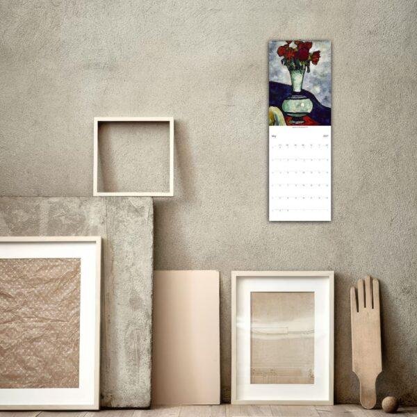 2027 wall calendar with floral art hanging on textured wall