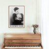 Framed vintage jazz singer poster above wooden piano